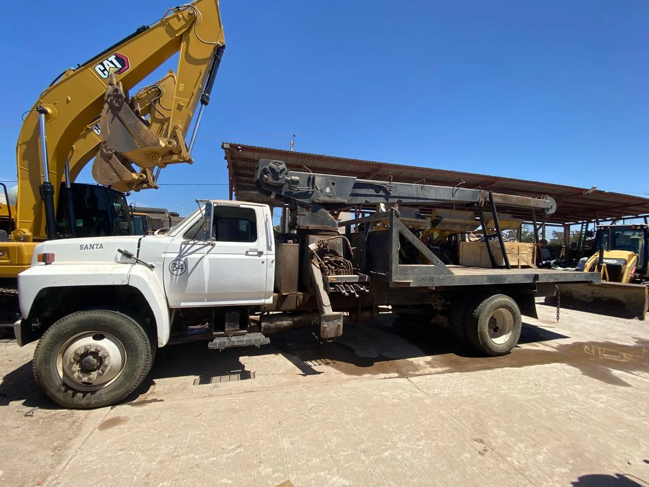 «Santa» #34 — camion grua Santa con excavadora CAT detras